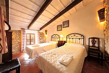 A bedroom with two twin beds and a chair