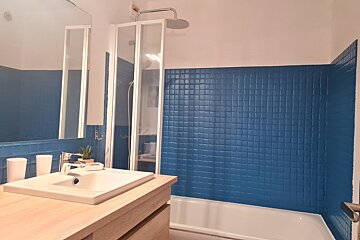 A bathroom with blue tiles and a white sink