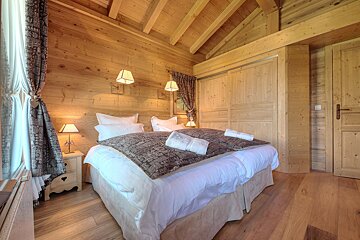 A wooden bedroom with a bed and a nightstand
