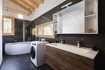 A bathroom with a washing machine and a sink