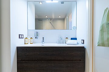 A bathroom with a laundry bag hanging on the wall