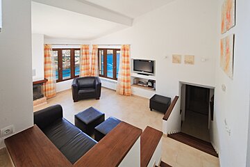 A living room with a couch a chair and a flat screen tv