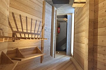 A wooden hallway with shelves and hooks on the wall