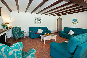 A living room with two blue couches and two chairs