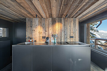 A kitchen with wood paneling and a stainless steel counter top