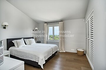 A bedroom with a bed and a window that says made in lanssens provence immobilier