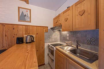 A kitchen with wooden cabinets and a toaster oven