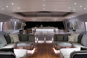 A living room on a boat with a bar in the background