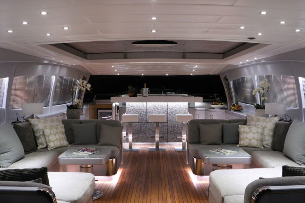 A living room on a boat with a bar in the background