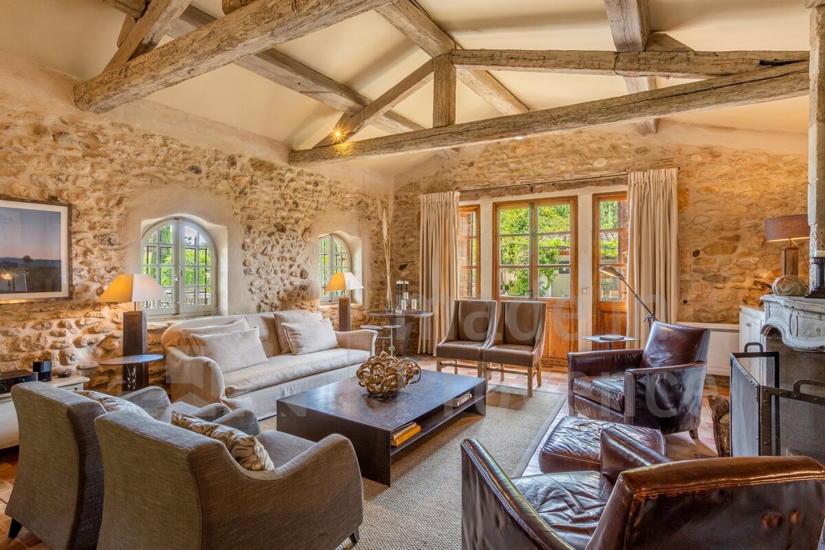 A living room with a stone wall and wooden beams