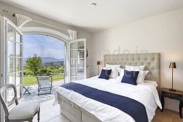 A bedroom with a large bed and a view of the mountains