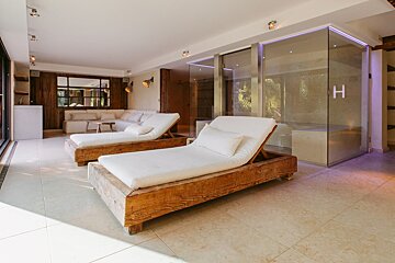 Two lounge chairs in a room with the letter h on the wall