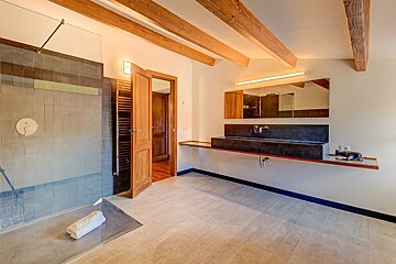 A bathroom with a sink and a walk in shower