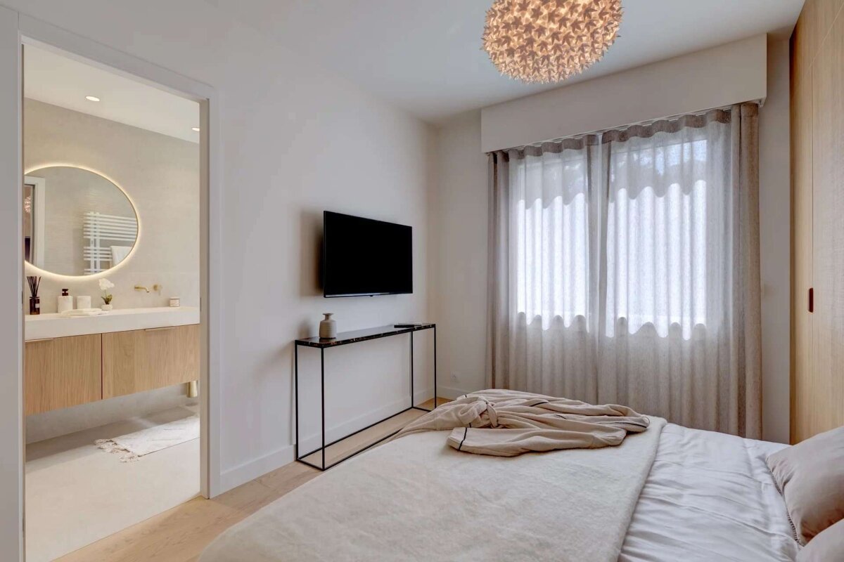 A bedroom with a flat screen tv on the wall