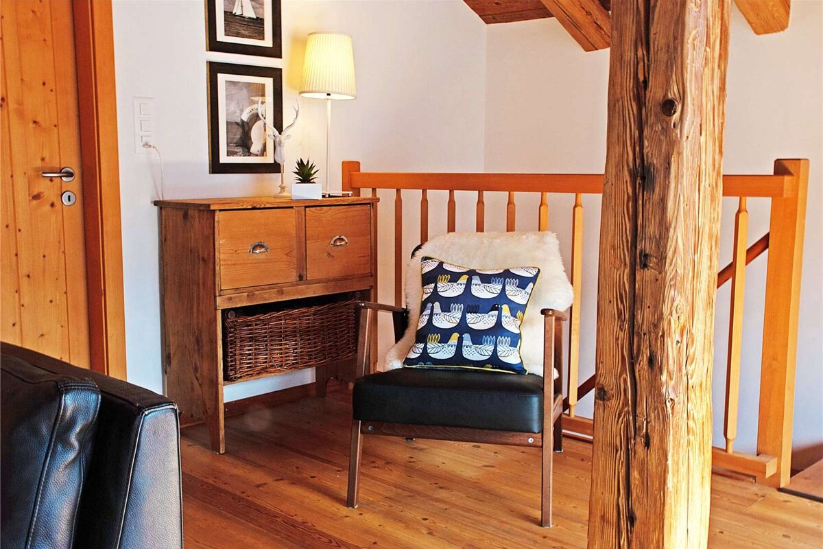 A chair with a pillow on it that has birds on it