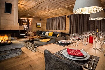 A living room with a fireplace and a dining table