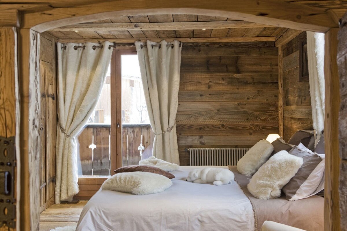 A wooden bedroom with a bed and a window