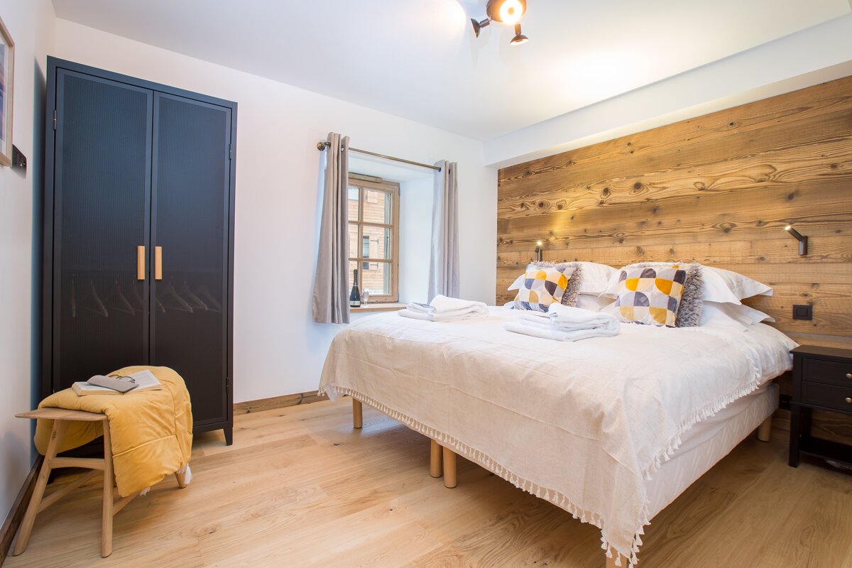 A bedroom with a bed and a wooden wall