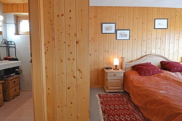 A bedroom with wood paneled walls and a bed