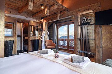A bedroom with a sliding glass door leading to a balcony