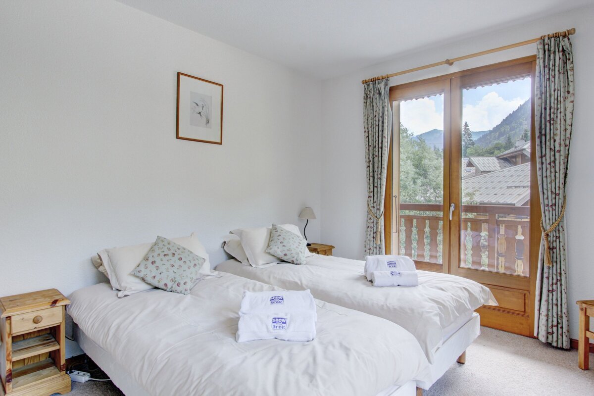 A hotel room with two beds and a balcony