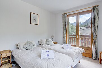 A hotel room with two beds and a balcony