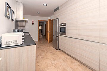 A kitchen with a stainless steel refrigerator and a microwave
