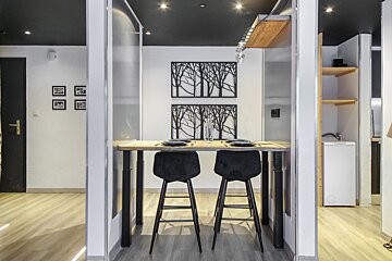 A dining room with a table and two stools