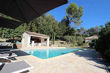 A large swimming pool with a gazebo in the background