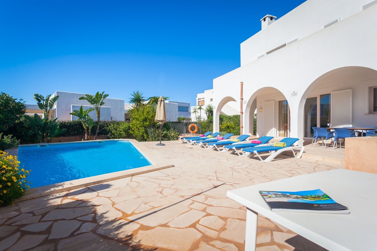 A table with a book on it sits in front of a swimming pool