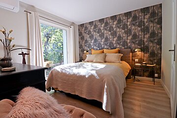 A bedroom with a large bed and a window