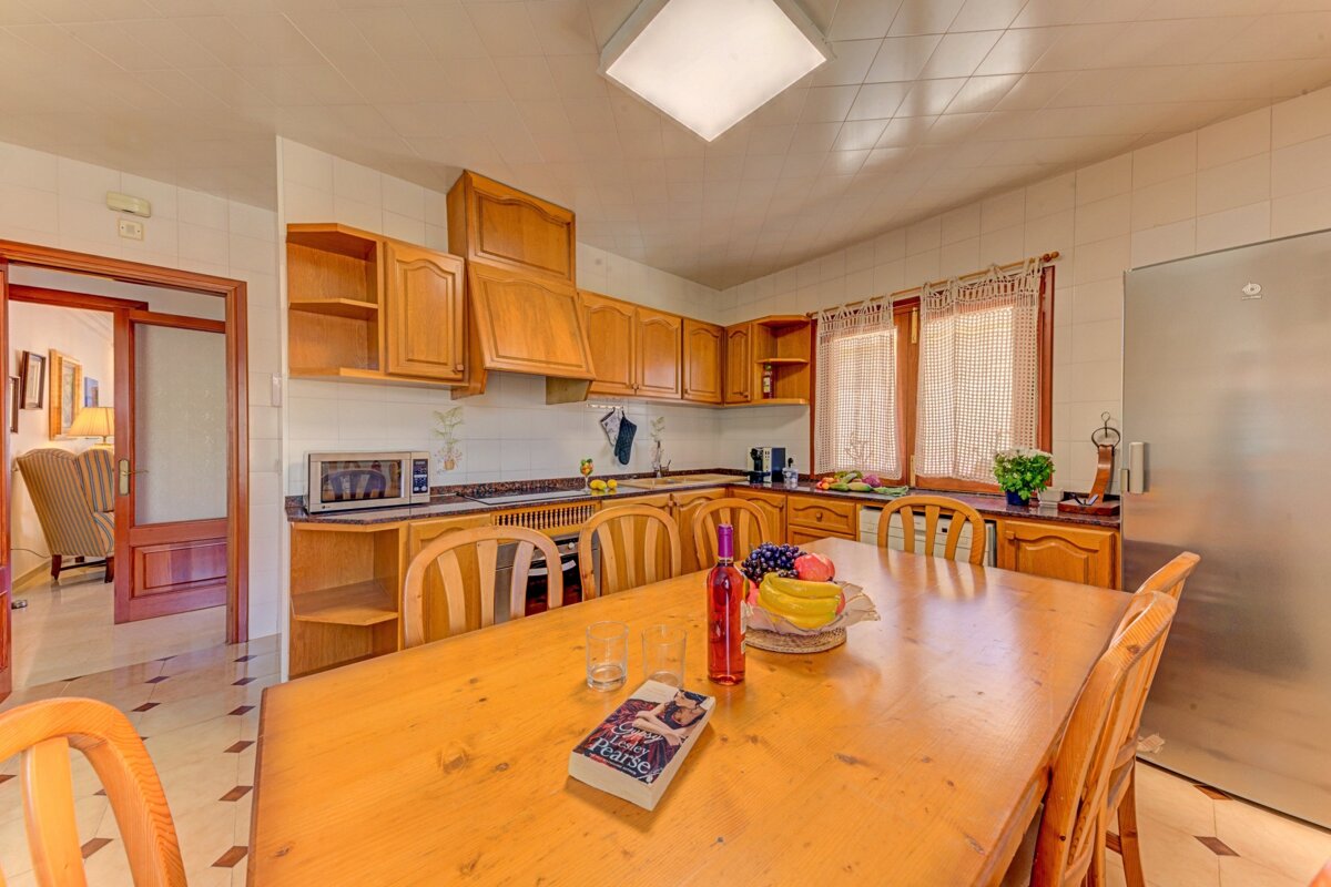 A kitchen with a table and chairs and a book on the table