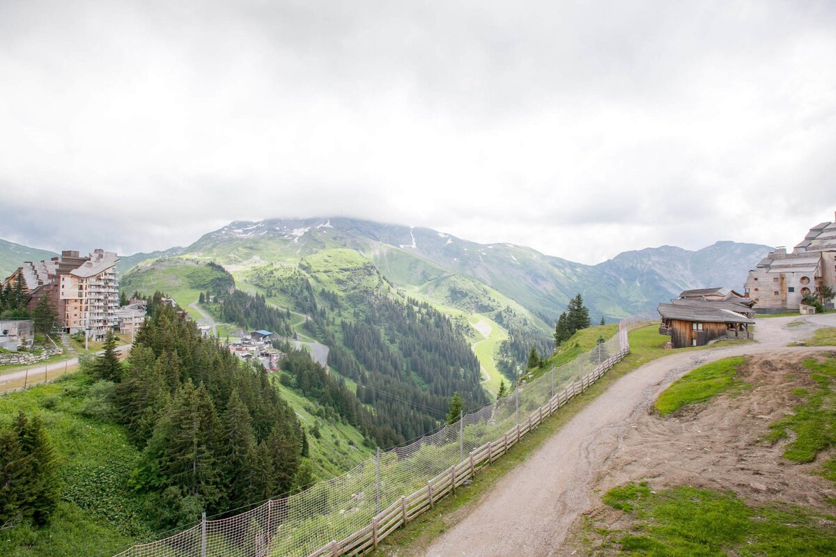 A fence surrounds a dirt road in the mountains