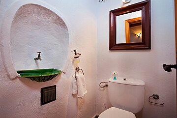 A bathroom with a toilet a sink and a mirror