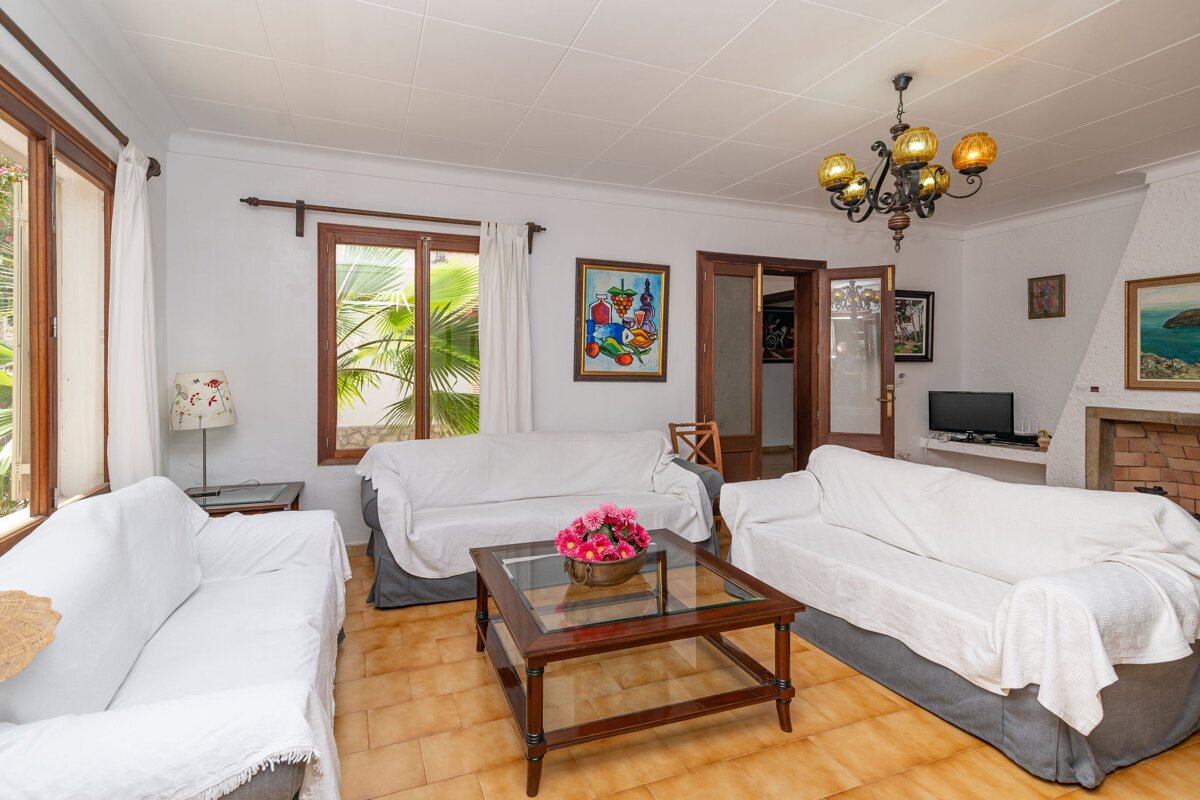 A living room with two white couches and a glass coffee table