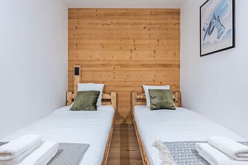 A bedroom with two beds and a picture on the wall