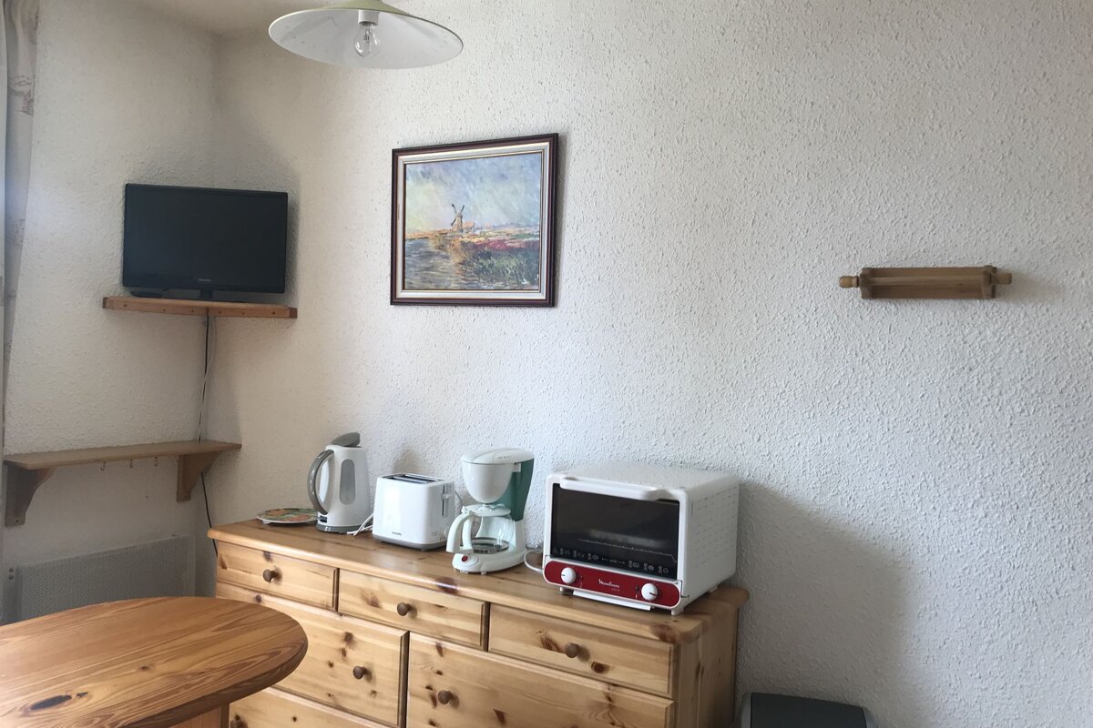 A corner of a kitchen with a picture on the wall