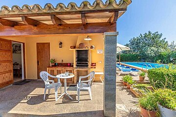 A patio with a table and chairs and a sign that says ' piscina ' on it