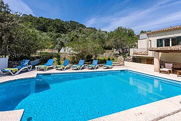 A large swimming pool surrounded by lawn chairs and a house
