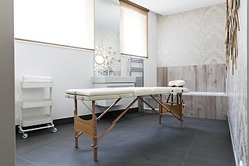 A massage table in a bathroom next to a sink