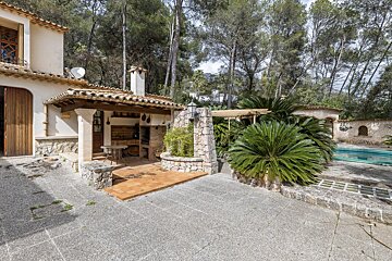 A house with a bbq and a satellite dish on the roof