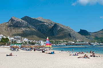 A sailboat on a beach with a mountain in the background