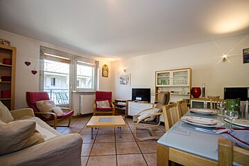 A living room with a couch and chairs and a flat screen tv