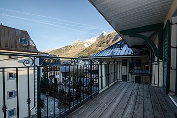 A balcony overlooking a city with mountains in the background