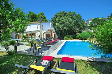 A large swimming pool surrounded by chairs and umbrellas