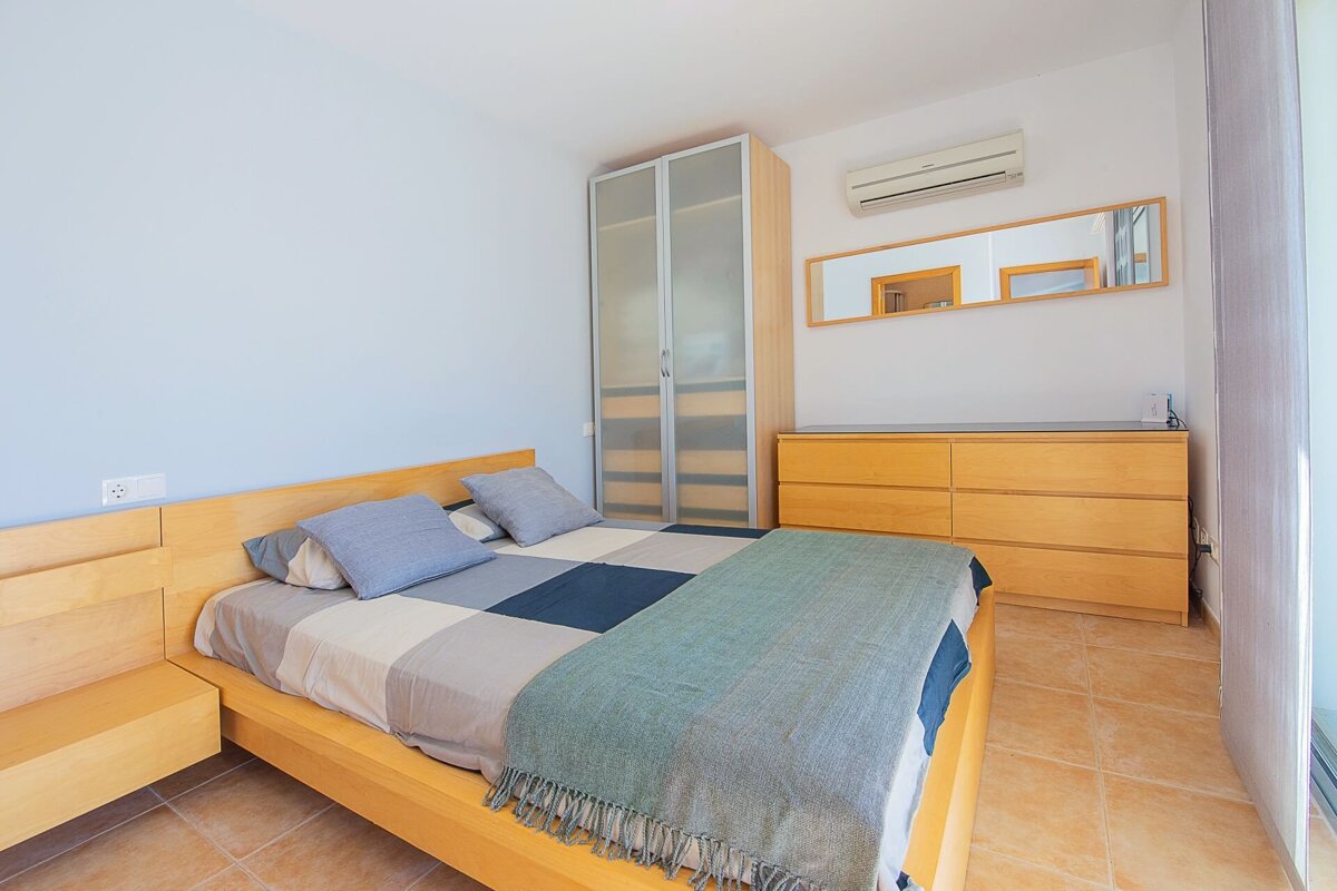 A bedroom with a bed dresser and mirror