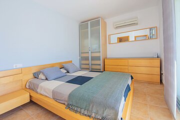 A bedroom with a bed dresser and mirror