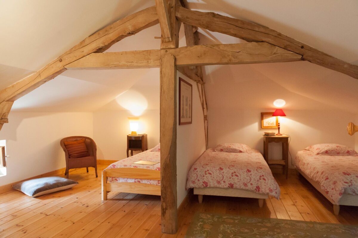 A bedroom with two beds and a chair in it