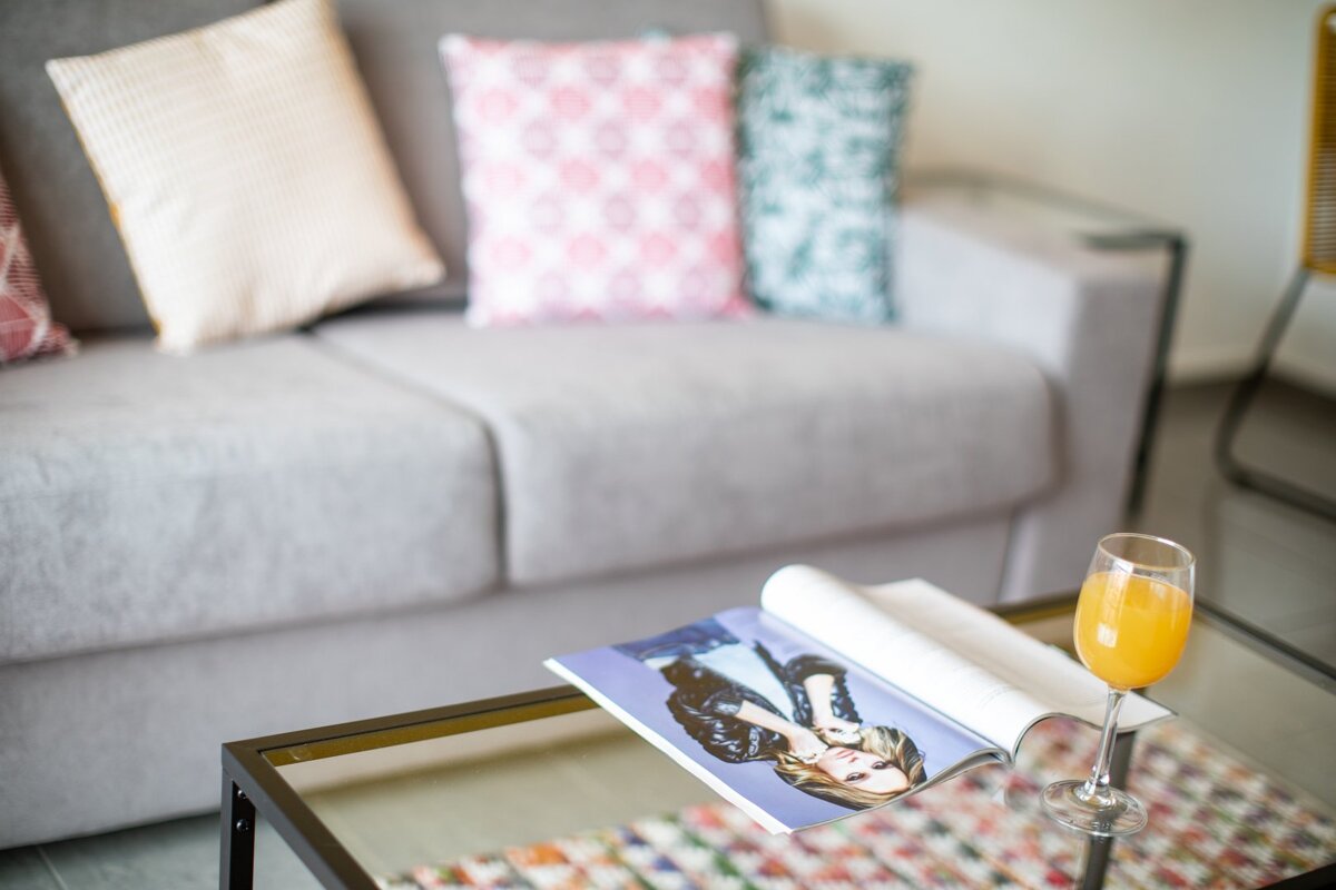 A magazine on a table next to a glass of orange juice