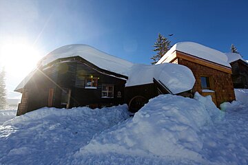 A snowy house with a sign that says ' altitude ' on it